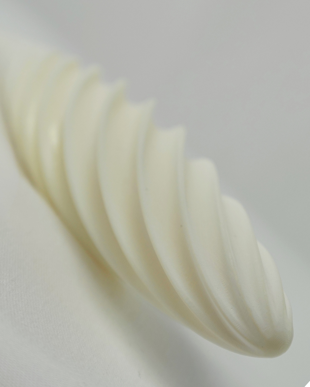 Close-up of the Fevowell Facer tip photographed from the front, highlighting the smooth ceramic surface and sculpted design
