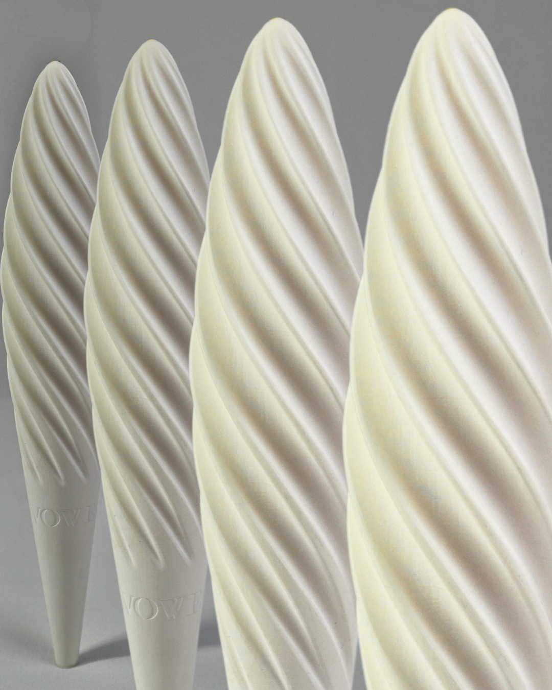 Four white Fevowell Facers standing in a row, showcasing their sculpted shape and minimalist ceramic design